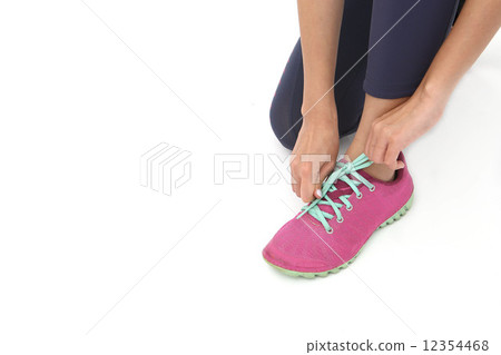 A woman who corrects a shoelace 12354468
