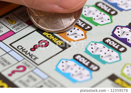 Woman scratching lottery ticket. It's published by BC Lottery Corporation  12359578