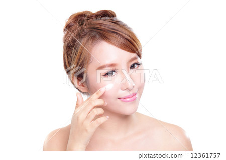 young woman applying moisturizer cream on face 12361757