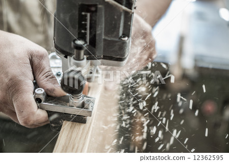 Blurred motion of carpenter working, preparing door for hinges Blurred motion of carpenter working, preparing door for hinges 12362595