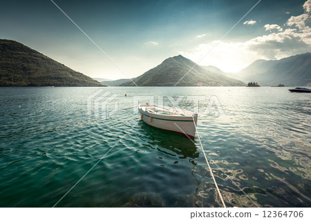 white rowboat moored at bay surrounded by mountains white rowboat moored at bay surrounded by mountains 12364706