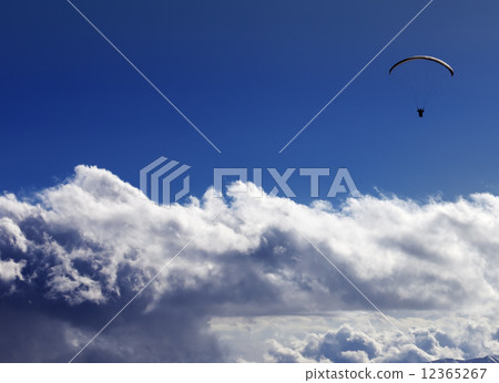 Silhouette of paraglider and blue sunny sky 12365267