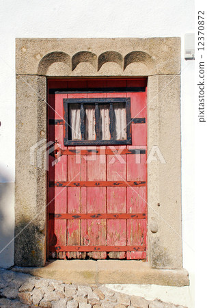 old red wooden door in white rural house, Portugal 12370872