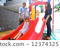 Asian Family with daughter at play on playground slide.  12374325