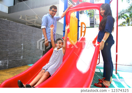 Asian Family with daughter at play on playground slide. Asian Family with daughter at play on playground slide. 12374325