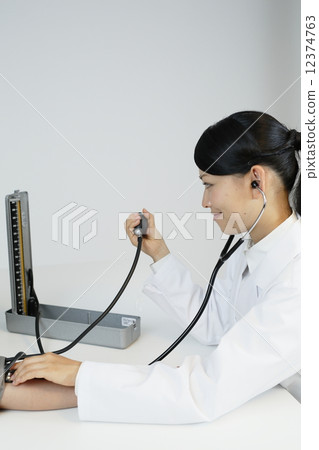 Female doctor measuring blood pressure gauge Female doctor measuring blood pressure gauge 12374763