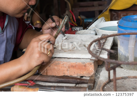 jeweler's hands while working making jewelry in Vientiane, Laos 12375397