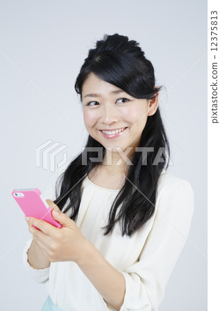 A young woman operating a smartphone 12375813