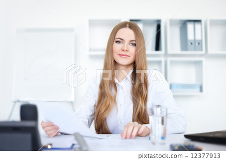 Portrait of a beautiful young smiling business woman doing some 12377913