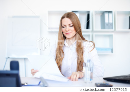 Portrait of a beautiful young smiling business woman doing some Portrait of a beautiful young smiling business woman doing some 12377915