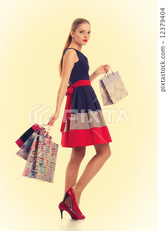 Portrait of young happy smiling woman with shopping bags 12379404