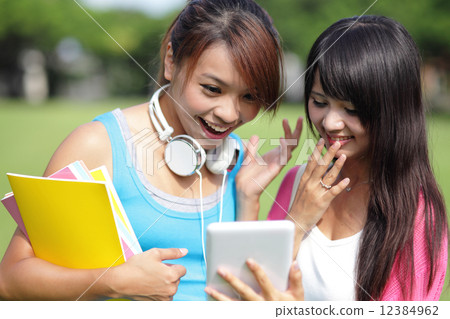 Girl students using tablet pc Girl students using tablet pc 12384962