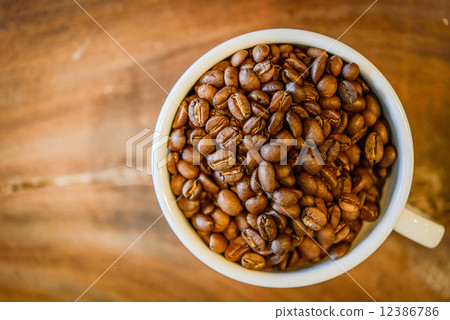 Coffee beans in cup on grunge wooden background 12386786