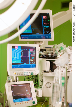 anaesthesiolog monitors in operation surgery room with green lights on 12386805