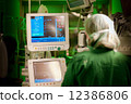 female anesthesiologist at monitor in operation surgery room with green lights on 12386806