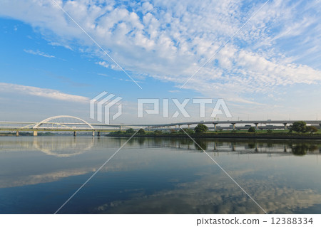 Five-color cherry tree bridge with blue sky spread and scenery reflected on the river Five-color cherry tree bridge with blue sky spread and scenery reflected on the river 12388334