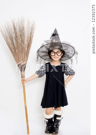 Asian witch child holding magic broom in Halloween dress Asian witch child holding magic broom in Halloween dress 12392375