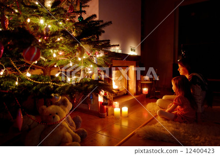 Young mother and her daughter by a fireplace 12400423