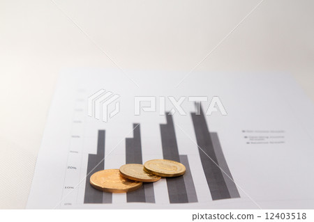 Gold coins on financial charts Gold coins on financial charts 12403518