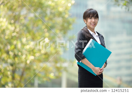 One successful chinese business woman holding document files along promenade 12415251