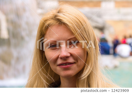 Urban portrait of attractive girl on background of the fountain 12423909
