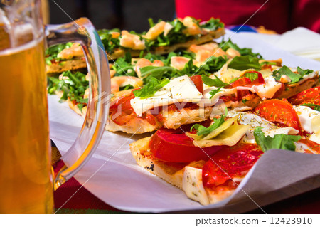 Italian appetizers and mug of beer in a restaurant 12423910