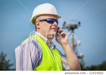 Worker with cell phone on a blue sky background  12424892