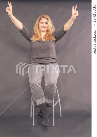 Happy attractive woman making a V-sign 12426330