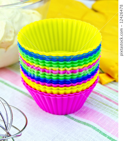 Molds for cupcakes with potholder and dough on tissue Molds for cupcakes with potholder and dough on tissue 12426478
