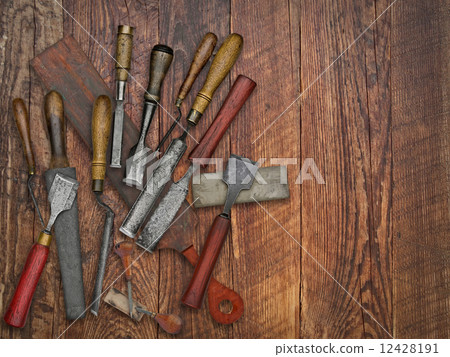 vintage chisels and stones collage over old wooden bench 12428191