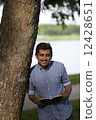 Young Asian man with with a book  12428651