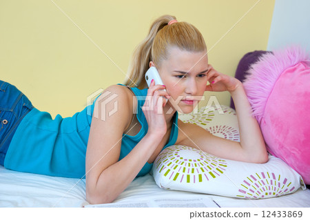 teen girl talking to mobile phone in her room 12433869