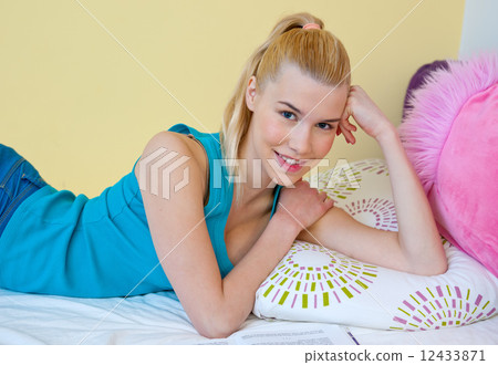 teen girl smiling in her bed 12433871