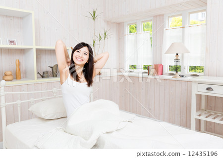 A woman relaxing in bed A woman relaxing in bed 12435196