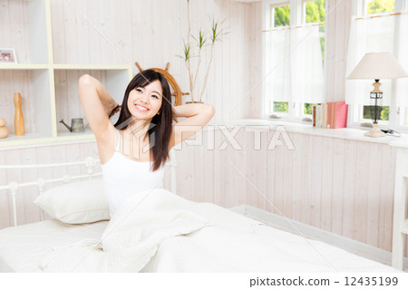 A woman relaxing in bed A woman relaxing in bed 12435199