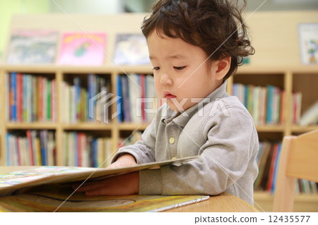Three years old reading a picture book 12435577