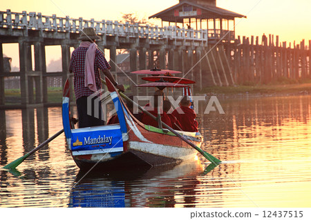 Burmese boatman and buddhist novice sitting in boat 12437515
