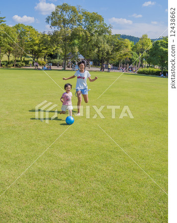 在草坪廣場上跟隨球的朋友妹妹 12438662