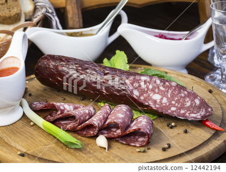 sausages on a wooden plate with vegetables in a restaurant 12442194
