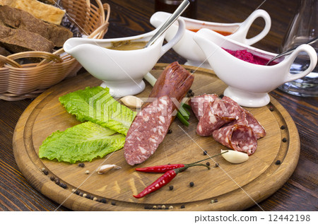 sausages on a wooden plate with vegetables in a restaurant 12442198