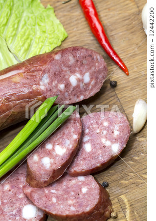 sausages on a wooden plate with vegetables in a restaurant 12442200
