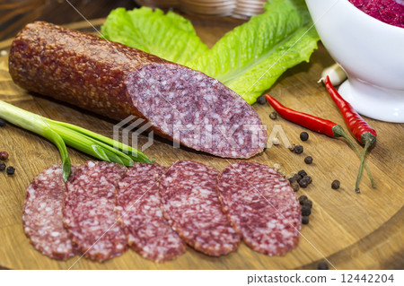 sausages on a wooden plate with vegetables in a restaurant 12442204