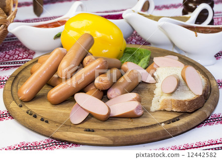 sausages on a wooden plate with vegetables in a restaurant 12442582
