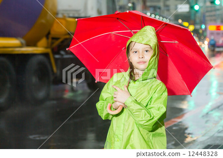 Young girl standing in rain with raincoat and umbrella Young girl standing in rain with raincoat and umbrella 12448328