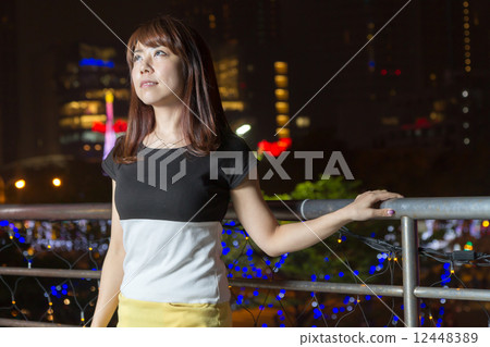 Pretty Asian woman in front of city lights 12448389