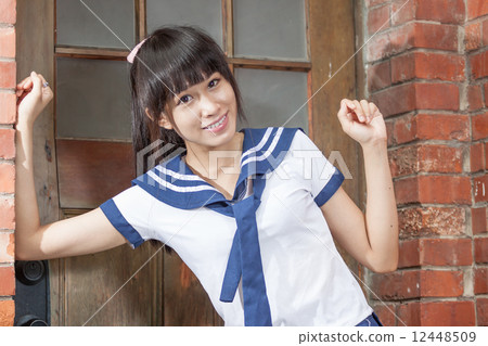 Asian schoolgirl in uniform outside school 12448509