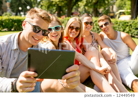 smiling friends with tablet pc making selfie 12449549