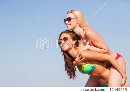 two smiling young women on beach two smiling young women on beach 12449659