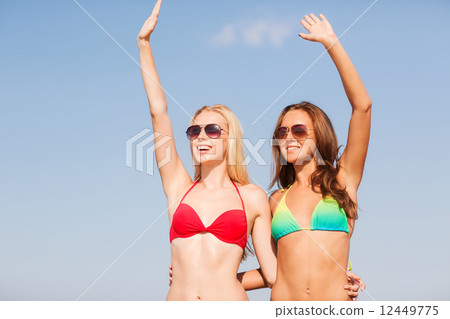 two smiling young women on beach two smiling young women on beach 12449775