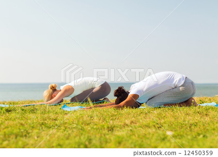 couple making yoga exercises outdoors couple making yoga exercises outdoors 12450359